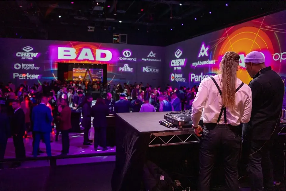 Full room at Bad After Dark in Las Vegas, guests on the floor under wall to wall projection of the event and partner logos
