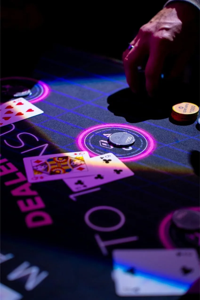 Close up of cards and chips on a branded table felt at Bad After Dark in Las Vegas