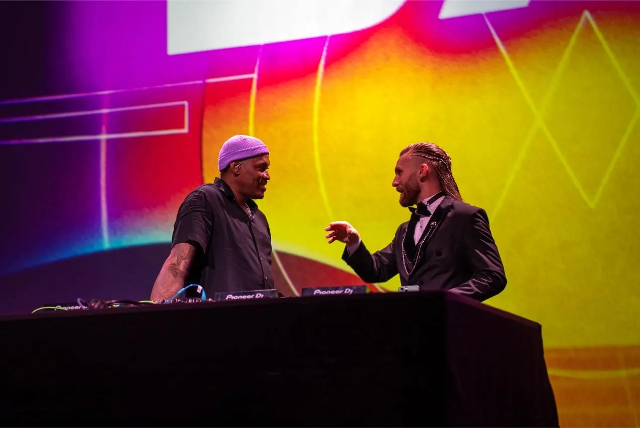 DJ booth at Bad After Dark in Las Vegas, the DJ talking with a guest in black tie