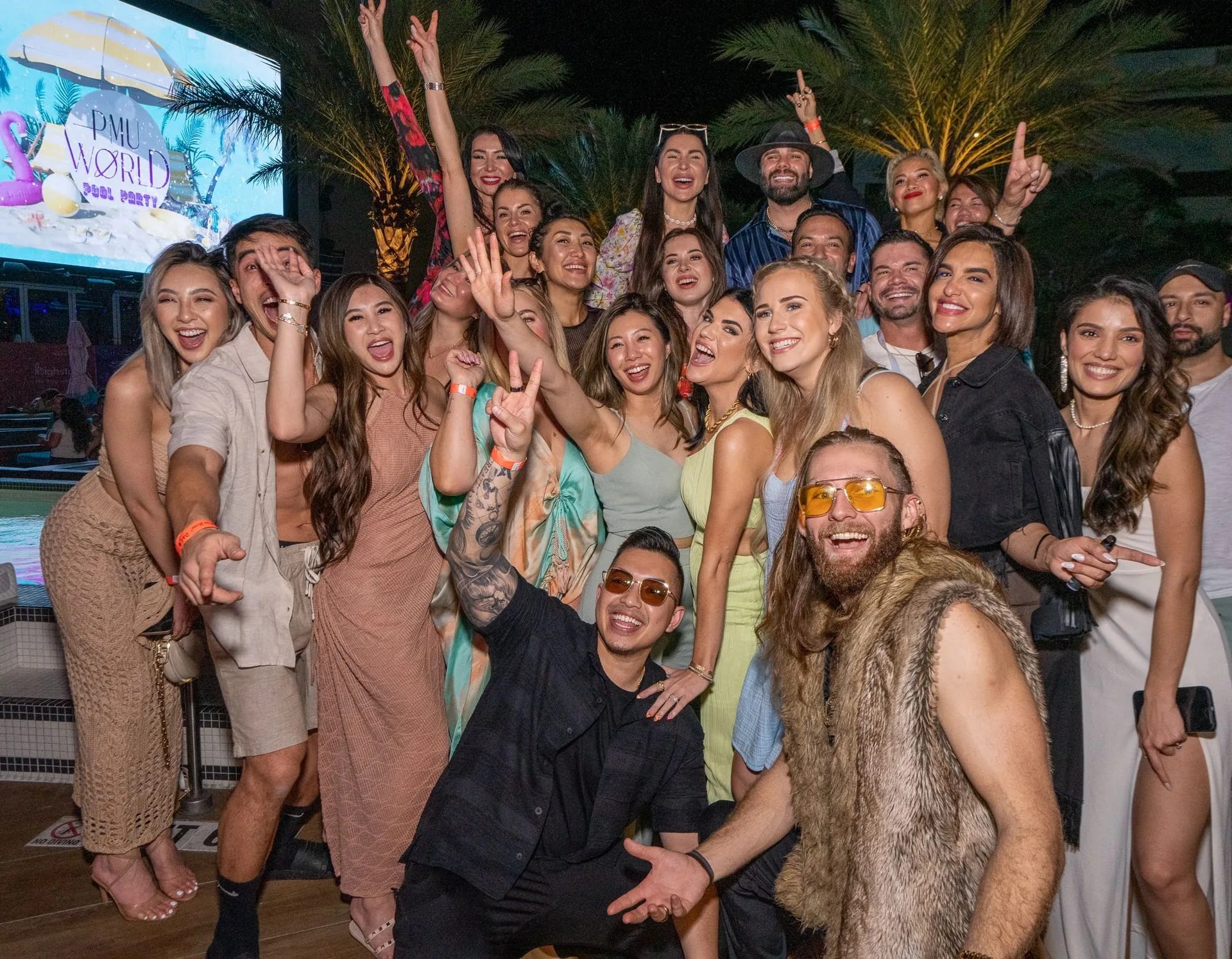 A crowd of attendees posing together at the evening party at PMU World 2023, the Seminole Hard Rock Hotel & Casino in Hollywood, Florida
