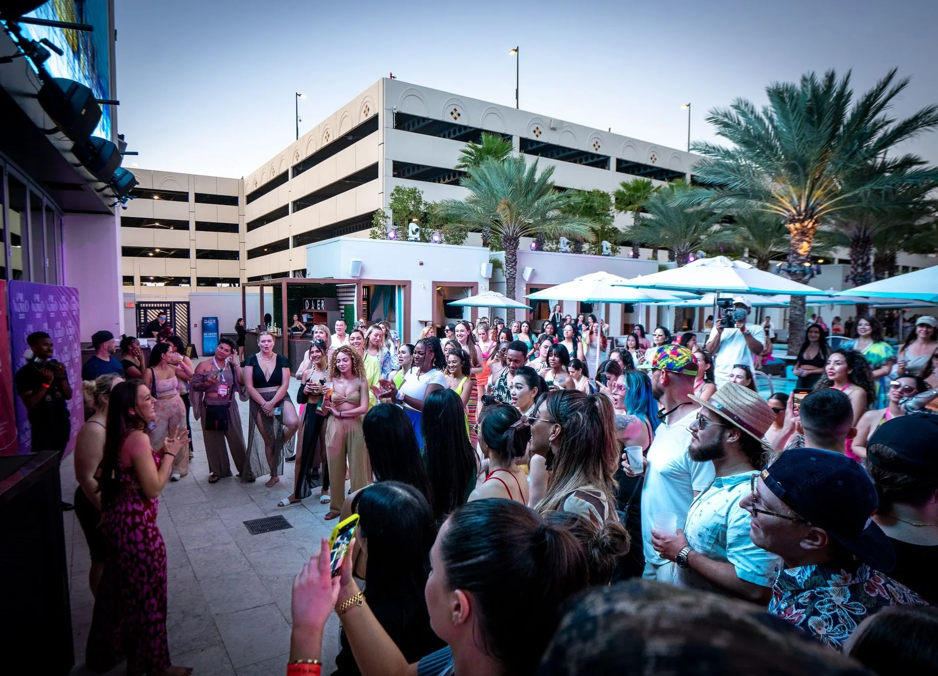 Attendees filling the pool deck at sunset at PMU World 2023, the Seminole Hard Rock Hotel & Casino in Hollywood, Florida