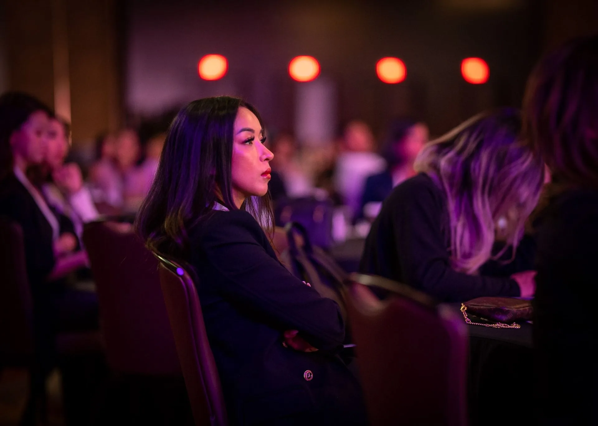 An attendee listening under purple stage light at PMU World 2023, the Seminole Hard Rock Hotel & Casino in Hollywood, Florida