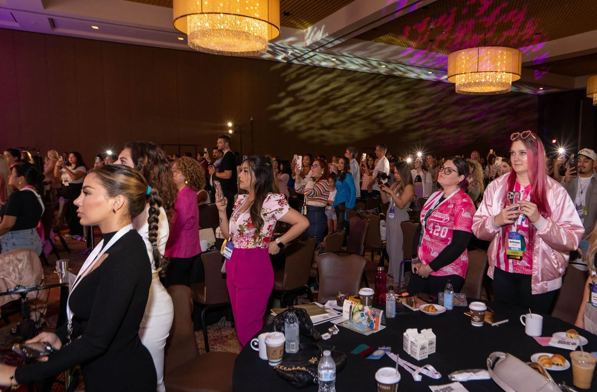 Attendees on their feet at their tables during the general session at PMU World 2023, the Seminole Hard Rock Hotel & Casino in Hollywood, Florida
