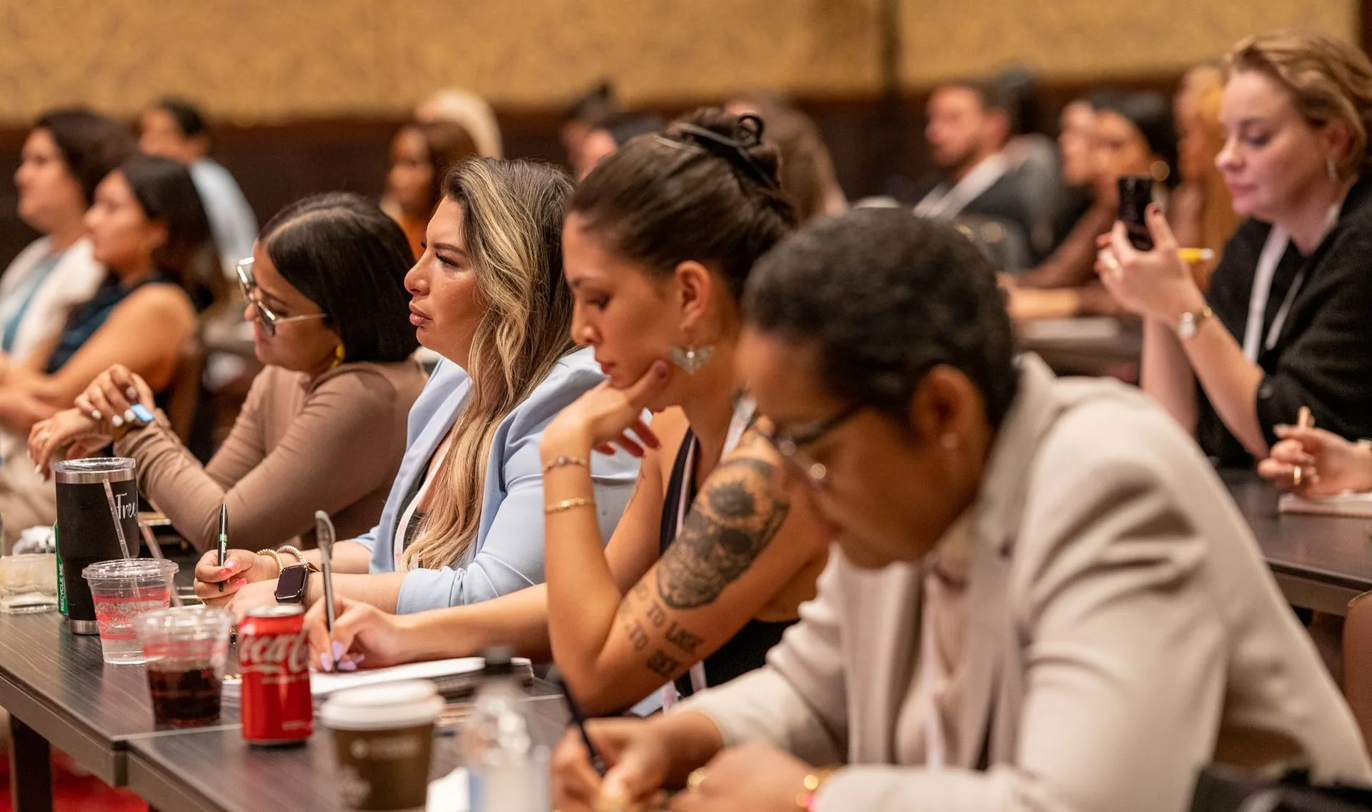 Attendees taking notes at their tables at PMU World 2023, the Seminole Hard Rock Hotel & Casino in Hollywood, Florida