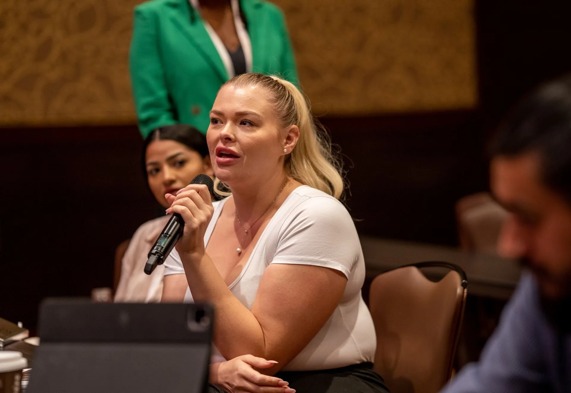 An attendee asking a question into a microphone during a session at PMU World 2023, the Seminole Hard Rock Hotel & Casino in Hollywood, Florida