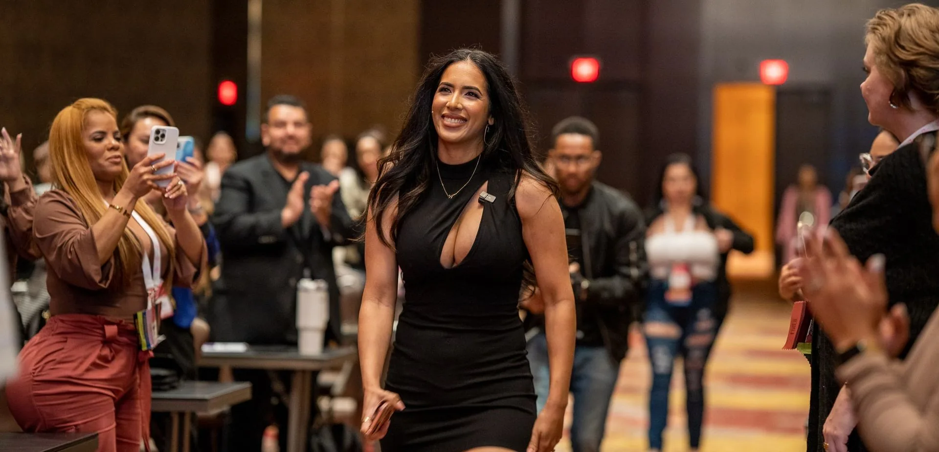 Attendees cheering a guest walking through the ballroom at PMU World 2023, the Seminole Hard Rock Hotel & Casino in Hollywood, Florida