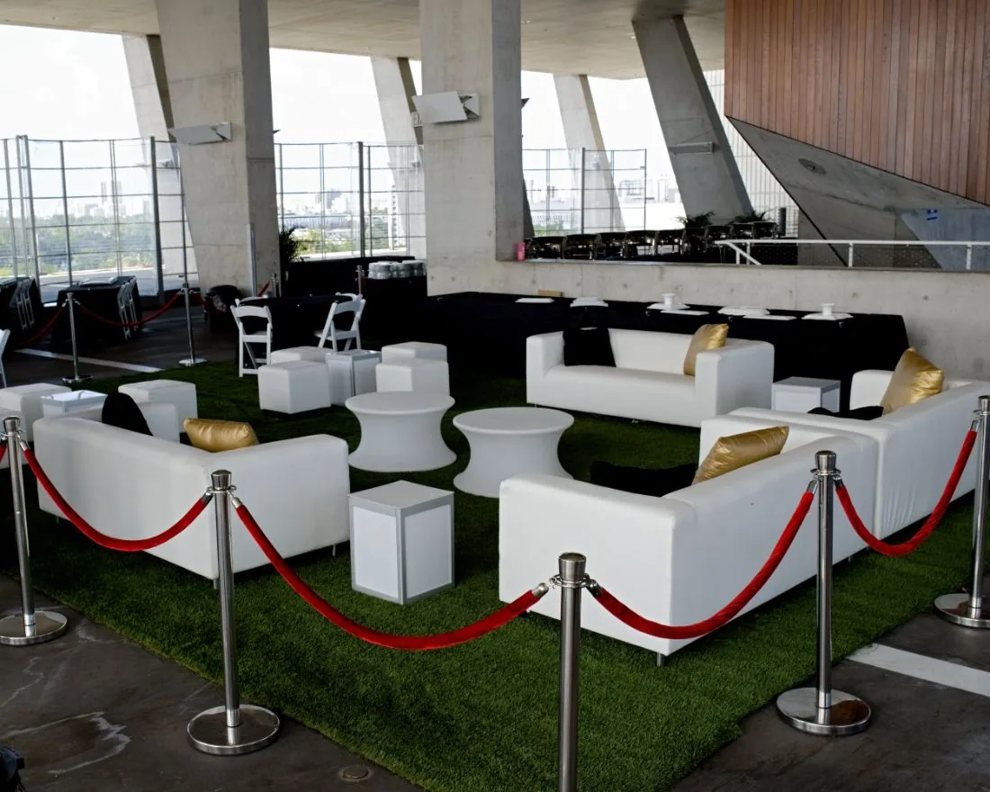 White lounge seating on turf behind red rope stanchions at Scaling With Systems LIVE in Miami
